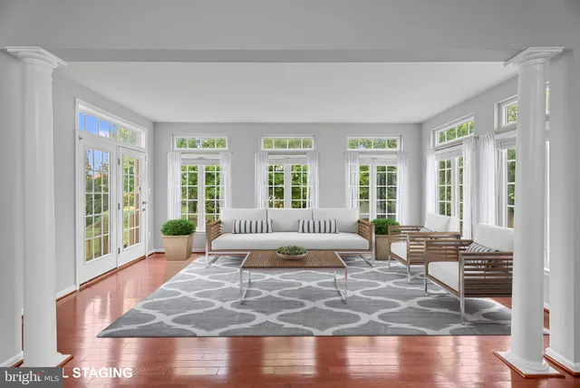a living room with large windows and wooden floor