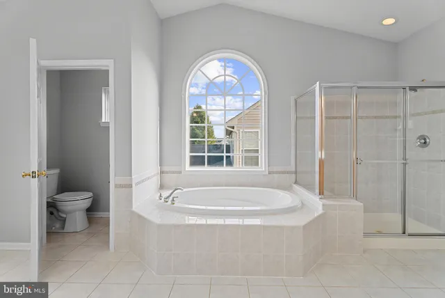 a spacious bathroom with a bathtub and a toilet
