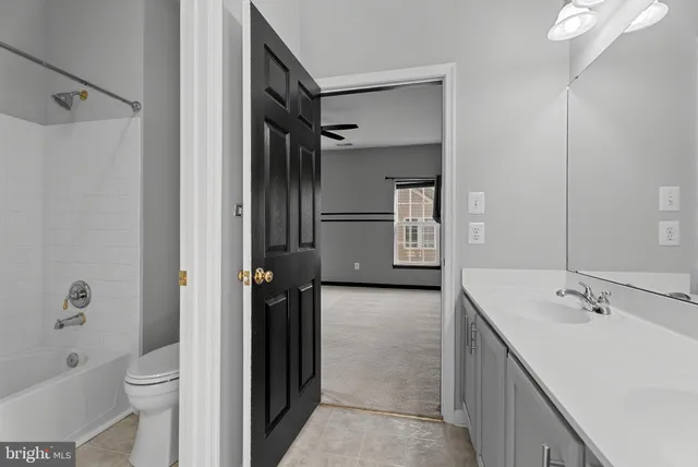 a bathroom with a tub sink toilet and mirror