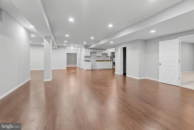 a view of an empty room with wooden floor