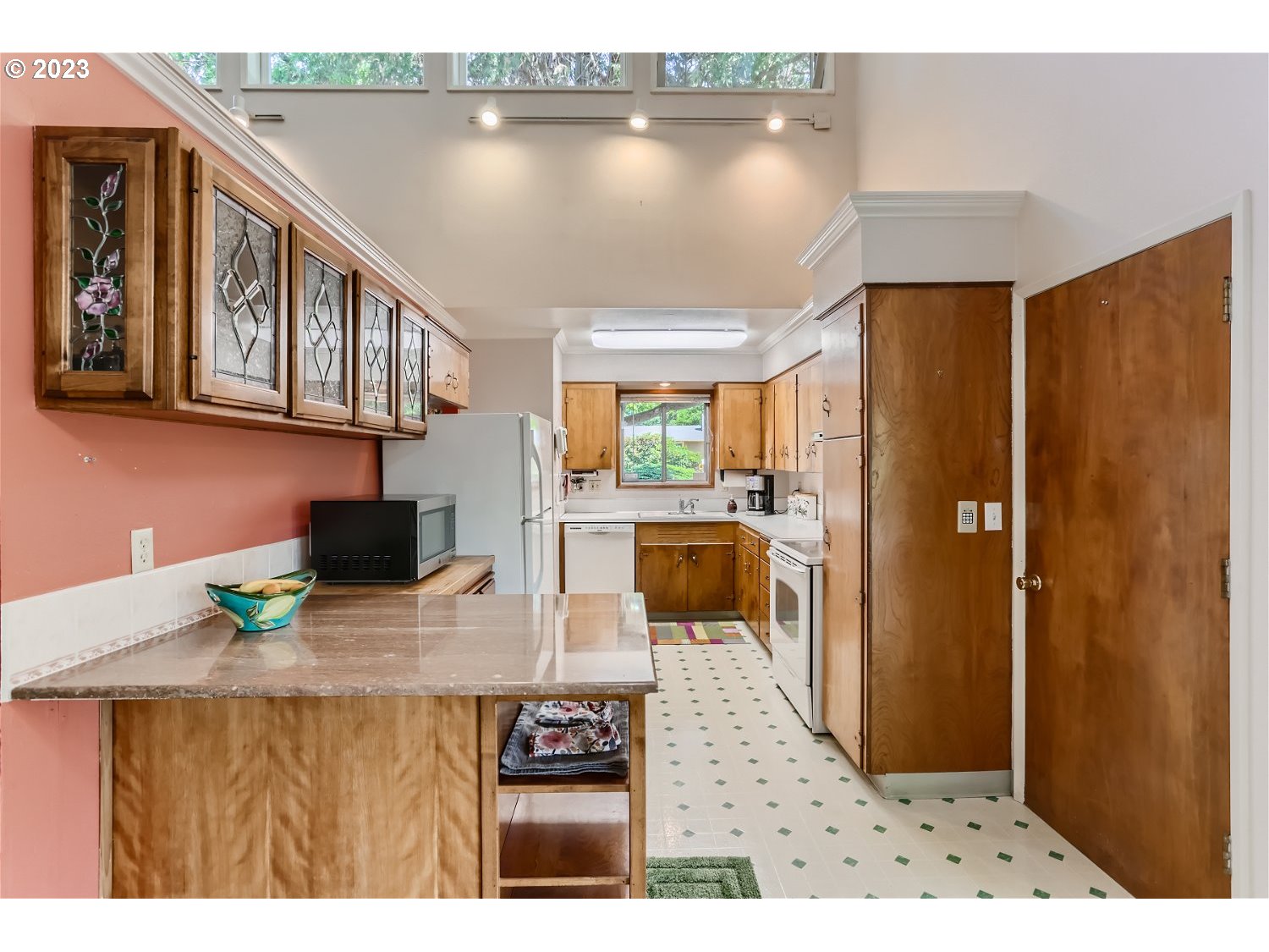 8220 Southwest Taylors Ferry Road Tigard, OR 97223 - Photo 10 of 38 a open kitchen with stainless steel appliances granite countertop a refrigerator a sink dishwasher with a dining table and chair