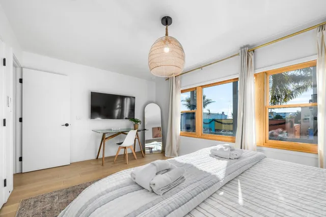 a bedroom with a bed and a flat tv screen on dresser