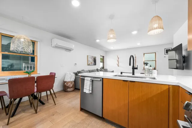 a kitchen with stainless steel appliances granite countertop a dining table chairs refrigerator and sink