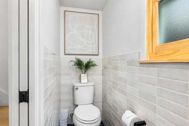 a white toilet sitting next to a shower