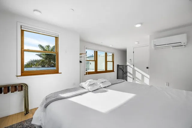 a bedroom with a bed and a painting on the wall