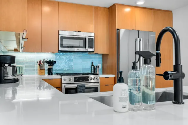 a kitchen with stainless steel appliances granite countertop a sink a stove and a refrigerator