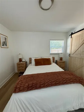 a bedroom with a bed and wooden floor