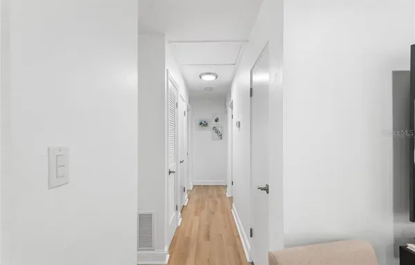 a view of a hallway with wooden floor