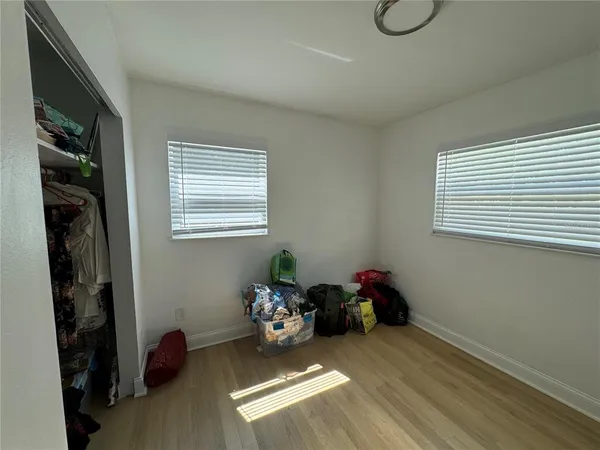 a view of a hallway with wooden floor and bathroom