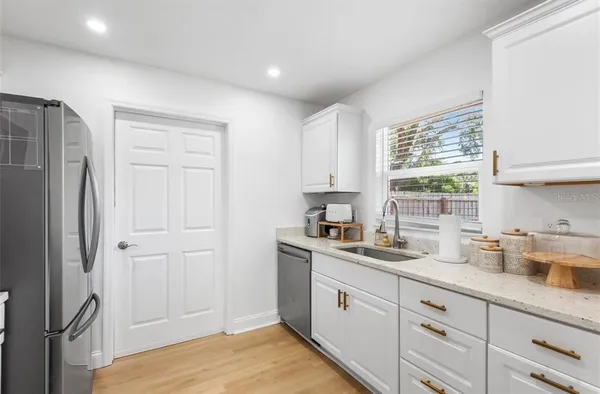 a kitchen with stainless steel appliances white cabinets and a window