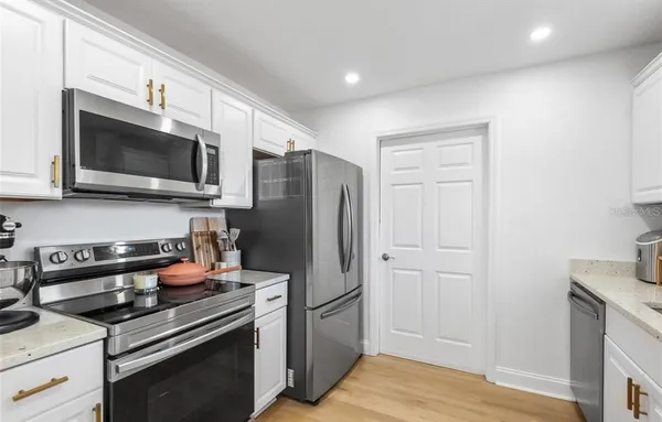 a kitchen with stainless steel appliances a stove microwave and refrigerator