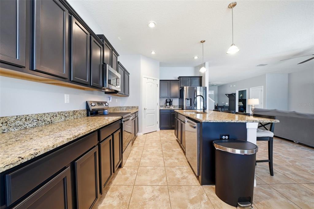 14604 Rannoch Moor Place Wimauma, FL 33598 - Photo 16 of 76 a kitchen with stainless steel appliances granite countertop a stove a sink dishwasher a refrigerator and a oven