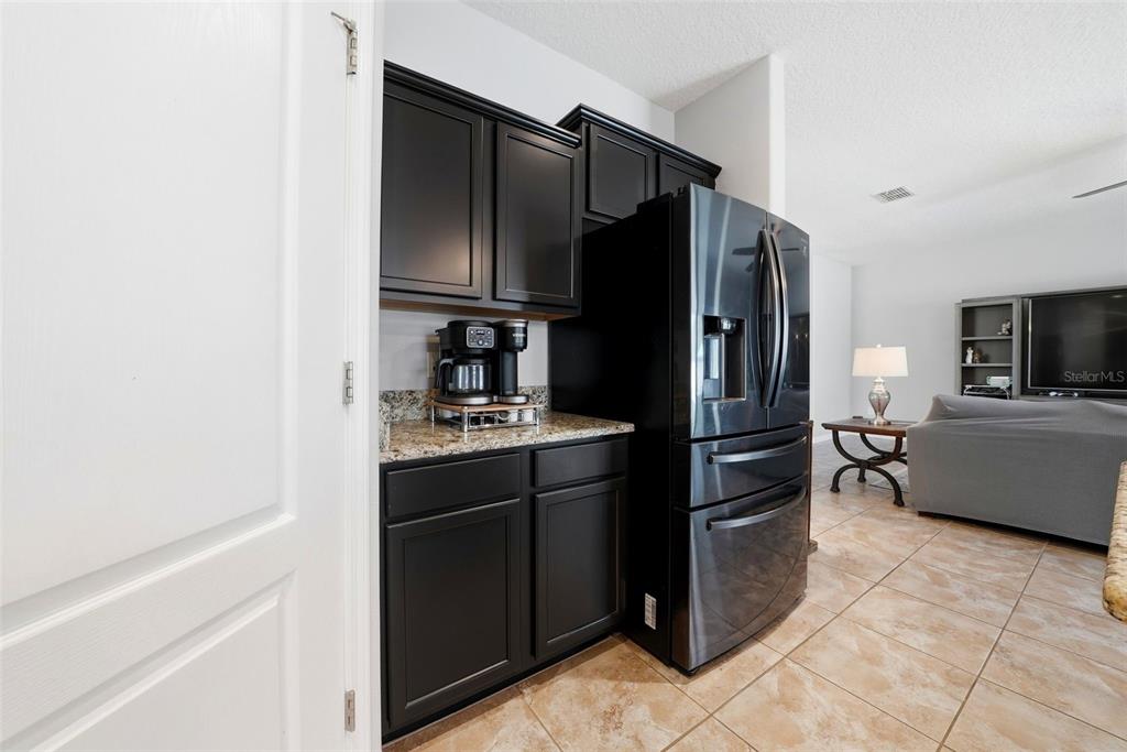 14604 Rannoch Moor Place Wimauma, FL 33598 - Photo 18 of 76 a kitchen with stainless steel appliances granite countertop a refrigerator and a sink