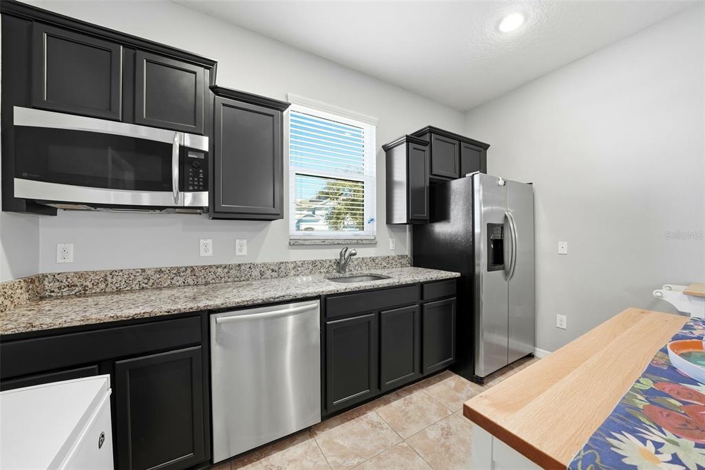 14604 Rannoch Moor Place Wimauma, FL 33598 - Photo 28 of 76 a kitchen with stainless steel appliances granite countertop a refrigerator and a stove top oven