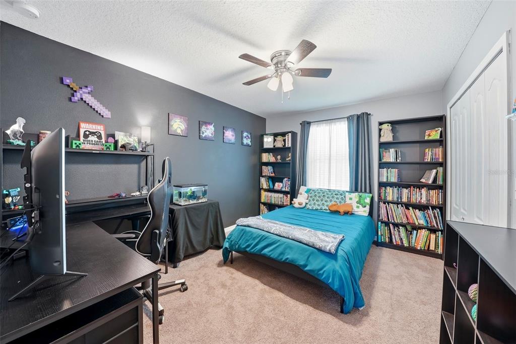 14604 Rannoch Moor Place Wimauma, FL 33598 - Photo 43 of 76 a bedroom with two beds and book shelf
