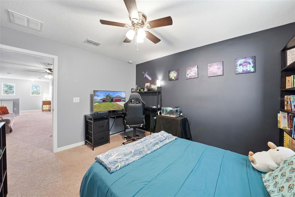 14604 Rannoch Moor Place Wimauma, FL 33598 - Photo 45 of 76 a bedroom with a bed and a flat tv screen on dresser