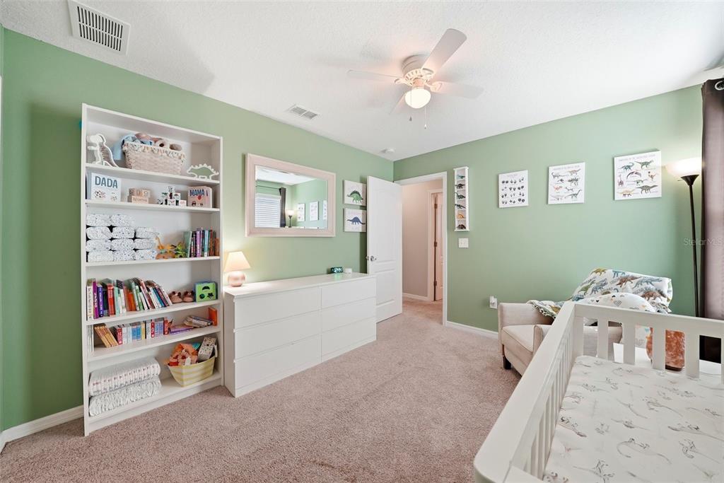14604 Rannoch Moor Place Wimauma, FL 33598 - Photo 51 of 76 a bed room with a bed and a book shelf