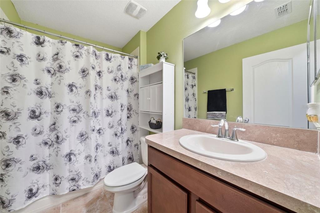 14604 Rannoch Moor Place Wimauma, FL 33598 - Photo 52 of 76 a bathroom with a granite countertop sink a toilet and a mirror