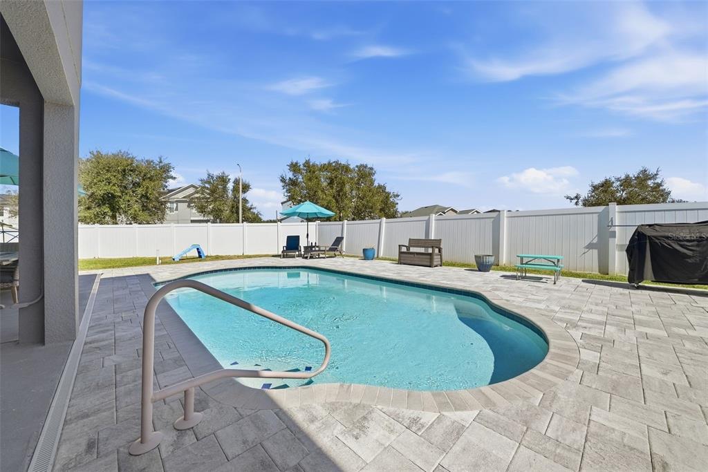 14604 Rannoch Moor Place Wimauma, FL 33598 - Photo 58 of 76 a view of a swimming pool with an outdoor seating and a yard