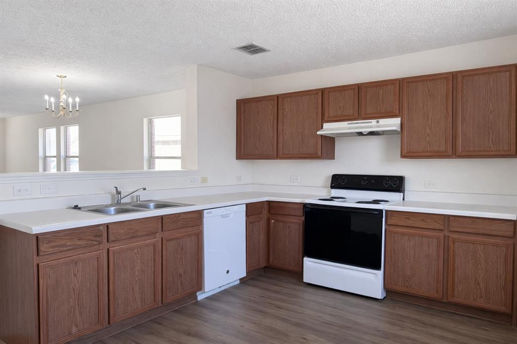 2512 Mitchell Lane Anna, TX 75409 - Photo 5 of 8 a kitchen with a sink and wooden cabinets
