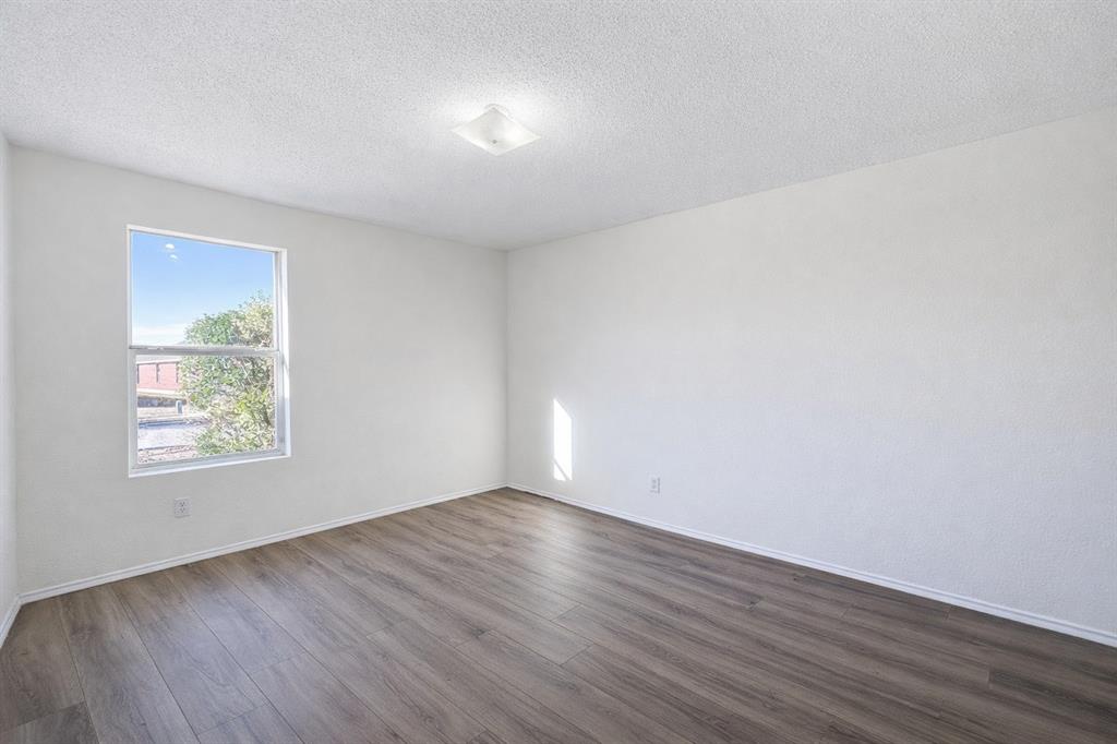 2512 Mitchell Lane Anna, TX 75409 - Photo 6 of 8 an empty room with wooden floor and windows