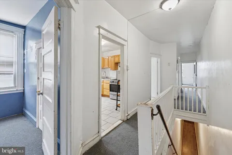 an empty room with chandelier fan and windows