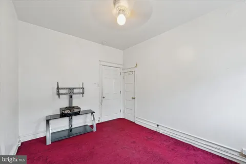 an empty room with windows and ceiling fan