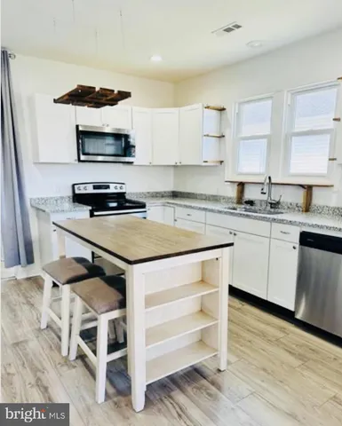 a kitchen with a sink cabinets and wooden floor