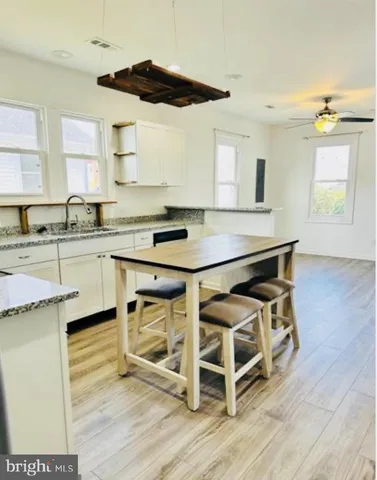 a view of a kitchen with furniture and wooden floor