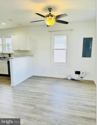 a view of a kitchen with wooden cabinet and a chandelier fan