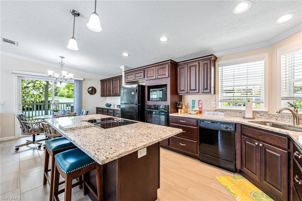 a kitchen with stainless steel appliances granite countertop table chairs sink and stove