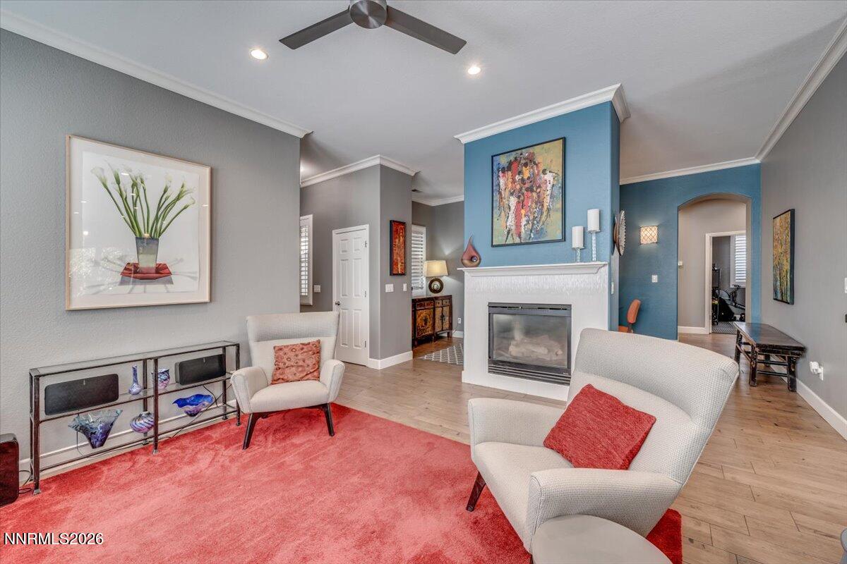 10562 Thistle Berry Court Reno, NV 89521 - Photo 20 of 44 a living room with furniture a fireplace and paintings on wall