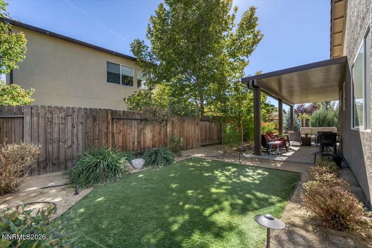 10562 Thistle Berry Court Reno, NV 89521 - Photo 42 of 44 a view of a backyard with plants and table and chairs under an umbrella