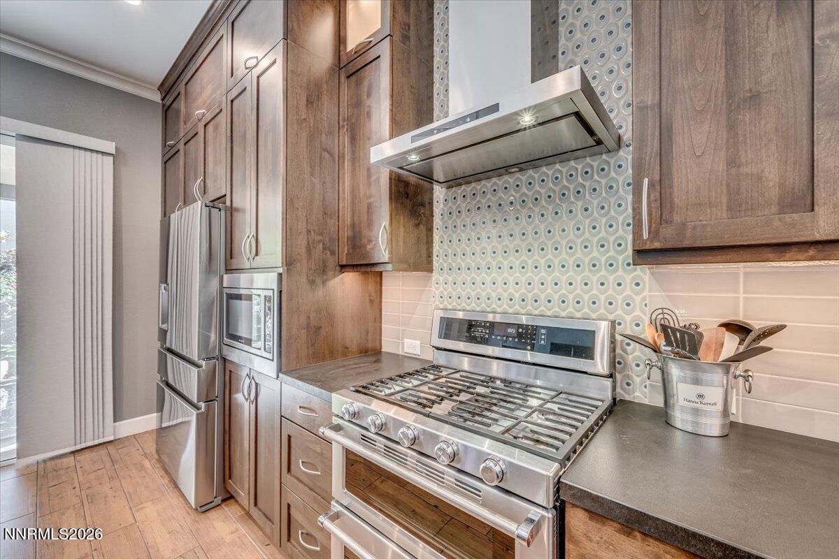 10562 Thistle Berry Court Reno, NV 89521 - Photo 6 of 44 a kitchen with granite countertop a stove and a refrigerator