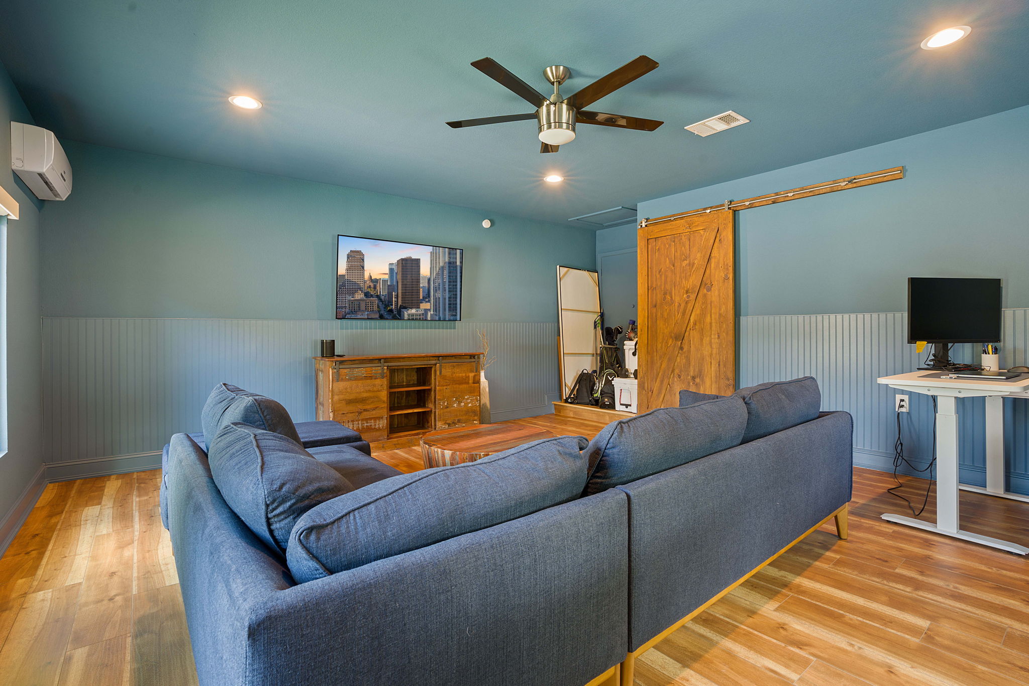 7110 Tawny Circle Austin, TX 78745 - Photo 15 of 30 Converted garage flex space with a barn door, wainscoting, recessed lighting, light wood-type flooring, and a ceiling fan