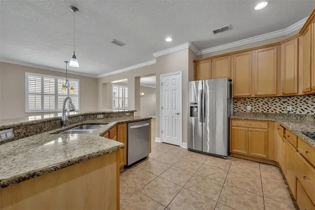 a kitchen with granite countertop a sink a counter space appliances and cabinets