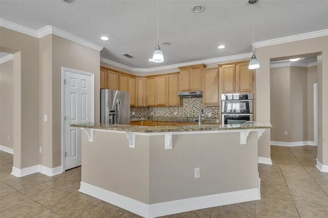 a view of kitchen with stainless steel appliances granite countertop refrigerator oven sink and cabinets