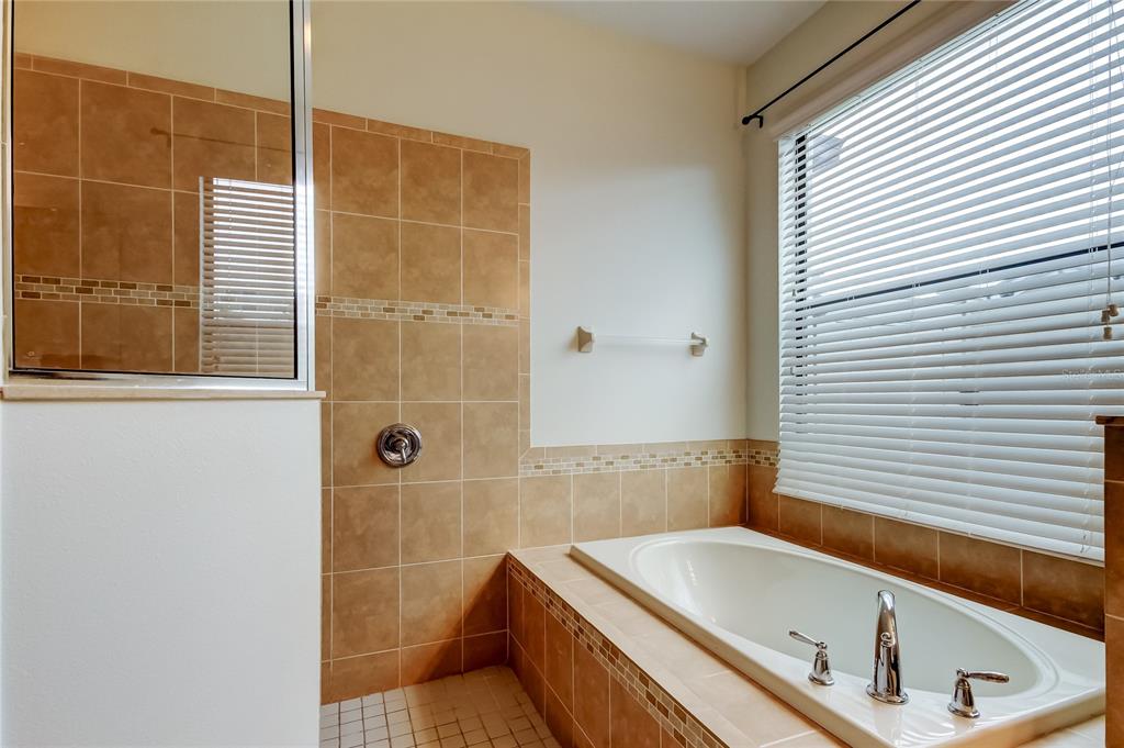 12747 Tikal Way Trinity, FL 34655 - Photo 17 of 40 a bathroom with a tub and a shower