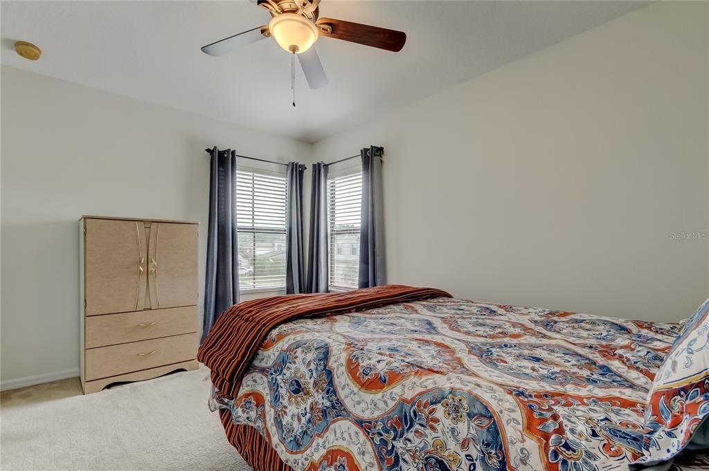 12747 Tikal Way Trinity, FL 34655 - Photo 26 of 40 a bedroom with a large bed and a chandelier