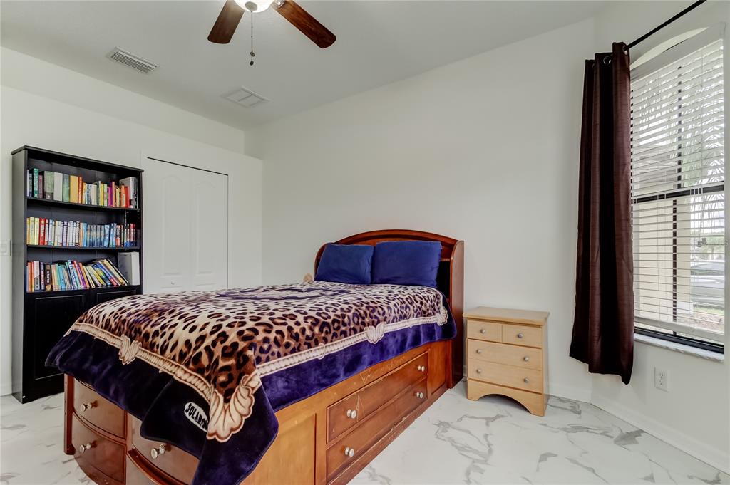 12747 Tikal Way Trinity, FL 34655 - Photo 29 of 40 a bedroom with a bed and a book shelf