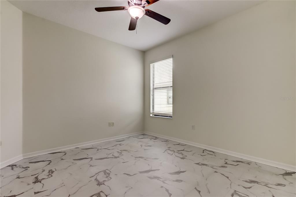 12747 Tikal Way Trinity, FL 34655 - Photo 31 of 40 an empty room with a window and ceiling fan