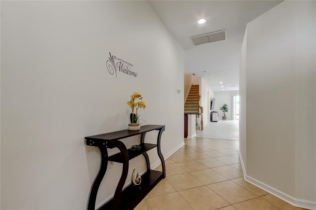 12747 Tikal Way Trinity, FL 34655 - Photo 36 of 40 a view of a hallway with a dining area and chandelier
