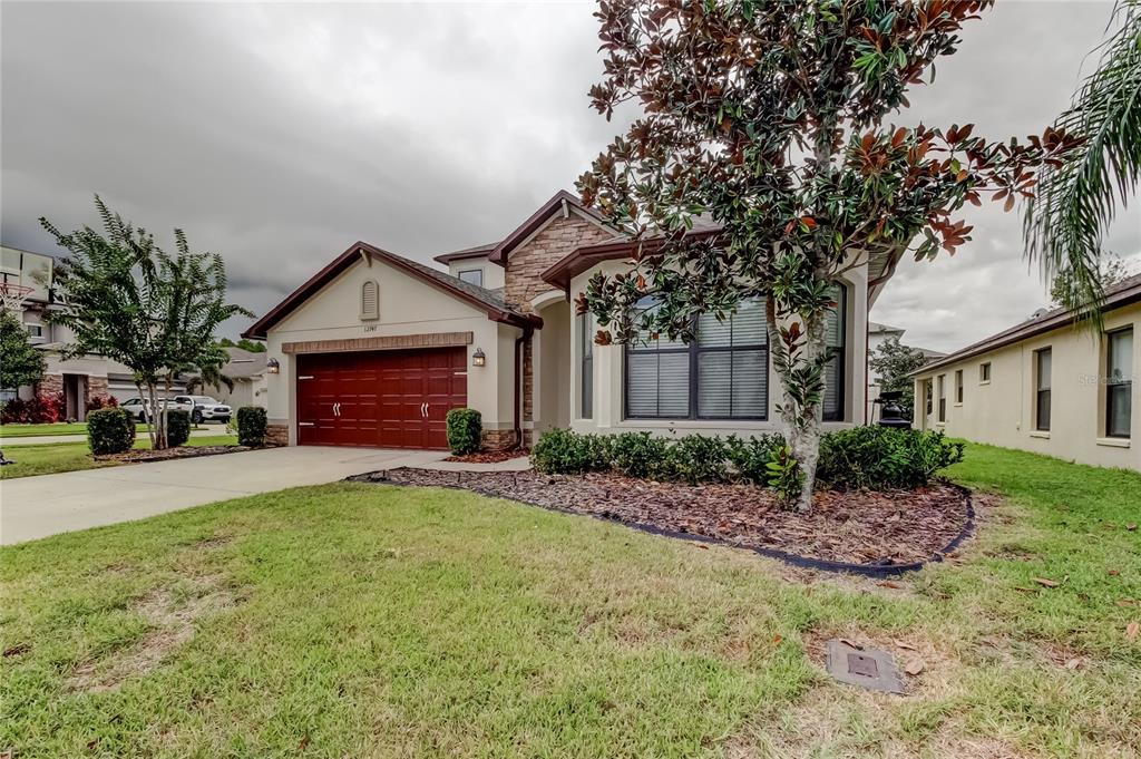 12747 Tikal Way Trinity, FL 34655 - Photo 38 of 40 a front view of a house with a garden