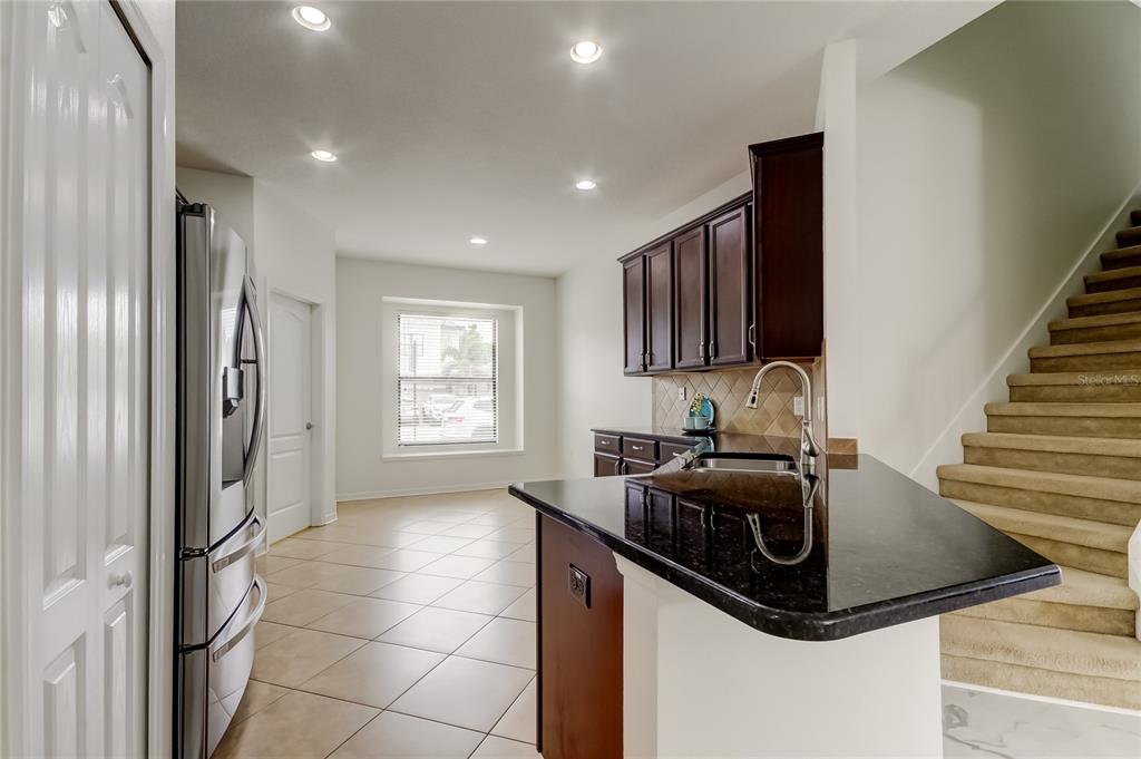 12747 Tikal Way Trinity, FL 34655 - Photo 6 of 40 a kitchen with stainless steel appliances a sink a microwave a refrigerator and cabinets
