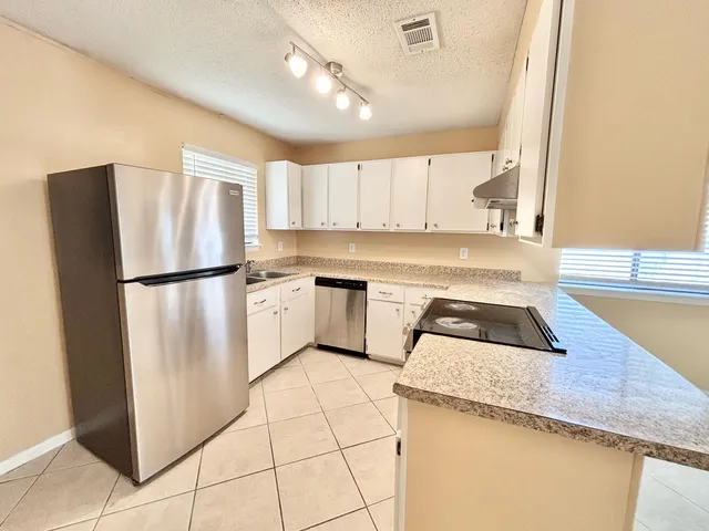 a kitchen with white cabinets and white appliances