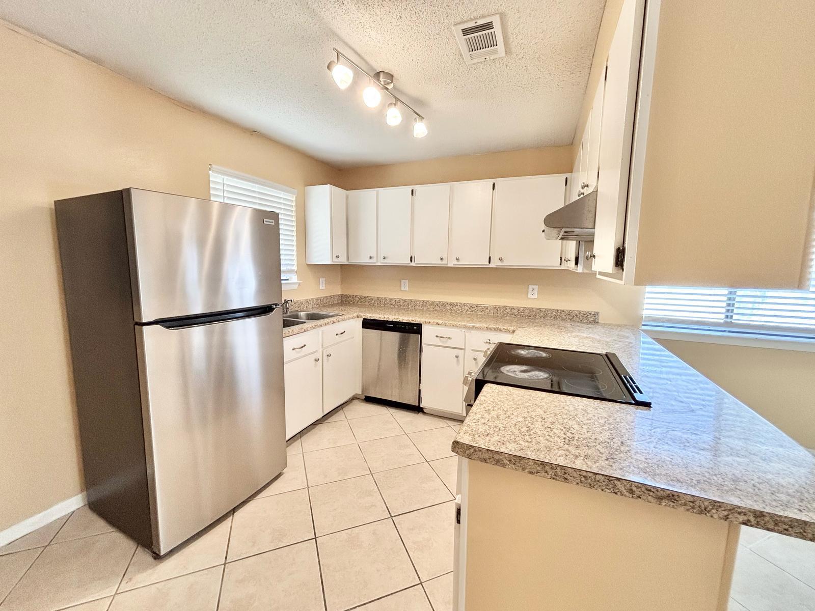 25 Blenheim Lane, Unit 4 Santa Rosa Beach, FL 32459 - Photo 5 of 13 a kitchen with white cabinets and white appliances