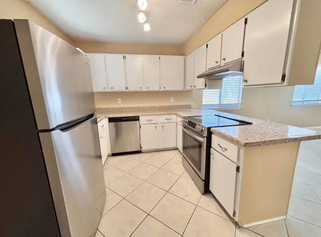a kitchen with white cabinets and white appliances