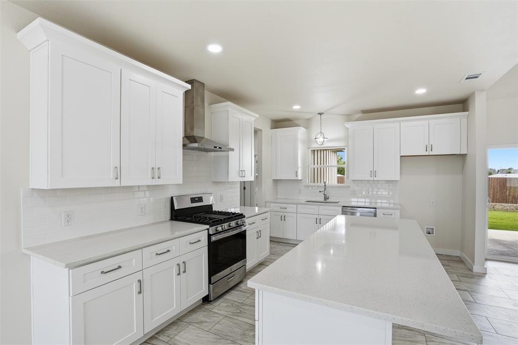 532 Highview Court Godley, TX 76044 - Photo 30 of 39 Bright kitchen featuring white shaker cabinetry, stainless steel appliances, white subway tile backsplash, light-toned countertops, and wood-finish tile flooring