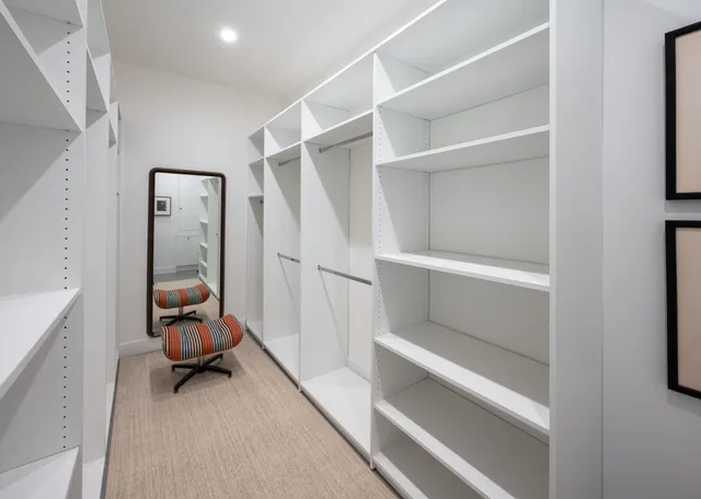 a view of a hallway with white walls and stairs