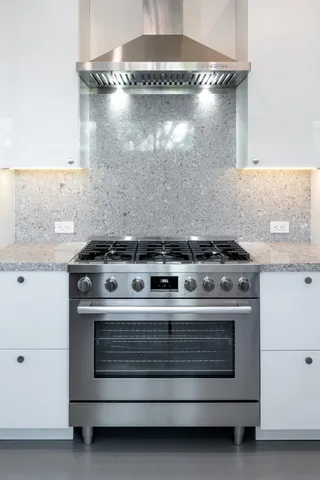 a stove top oven sitting inside of a kitchen